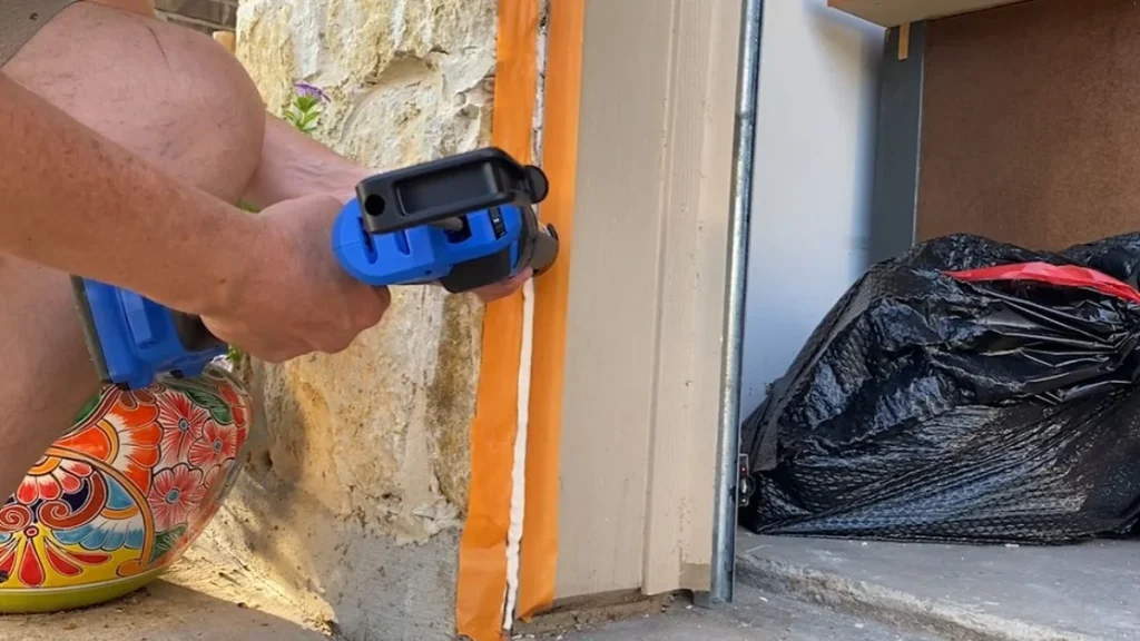 Applying caulk around garage door